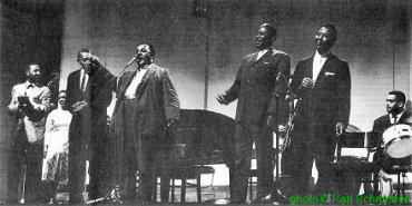 >Finale of the American Folk Blues Festival 1963 (October 8, 1963 at Deutsches Museum, Munich), (l to r) Lonnie Johnson, Willie Dixon (hidden), Victoria Spivey, Sonny Boy Williamson, Otis Spann (hidden), Big Joe Williams, Memphis Slim, Matt Murphy (hidden), Muddy Waters, Bill Stepney; source: Blues Forum Nr. 10 (2. Quartal 1983), p. 22/23: photographer: Karl Schneider