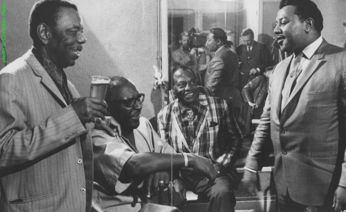 Champion Jack Dupree</b>, Sonny Terry, 'Bukka' White, Clifton James at the American Folk Blues Festival 1970 in Paris, France; In the background [actually: in the mirror!]: Kurt Mohr; source: Philippe Bas-Rabérin (ed.): Blues - Les Incontournables.- Paris (Éditions Filipacchi) 1994, pp. 126/127; photographer: Christian Rose