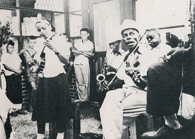 L A U R A   D U K E S, Mickey Mathis, Will Batts, Son Smith and Will Shade playing outside a drive-in shop in Memphis, early 1950s; source: Back cover of Flyright LP 113; photographer's name not given