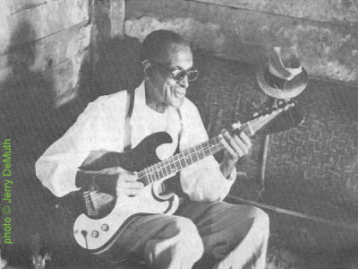 ' S L E E P Y'   J O H N   E S T E S at his home in Brownsville, TN, playing his Silvertone guitar, c. 1966; source: Photo (on p. 10) accompanying Jerry DeMuth's article 'Sleepy John Estes - Legend In A Shack' in Down Beat 39, # 19 (November 11, 1971), pp. 10, 29; photographer: Jerry DeMuth; click to enlarge!