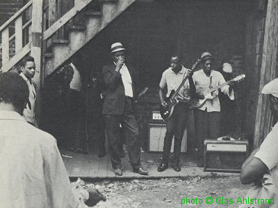 B I G   J O H N   W R E N C H E R & J O H N   L E E   G R A N D E R S O N at the corner of 14th and Newberry St., Chicago, IL; source: Nothing But The Blues, p. between 122 + 123; photographer: Clas Ahlstrand