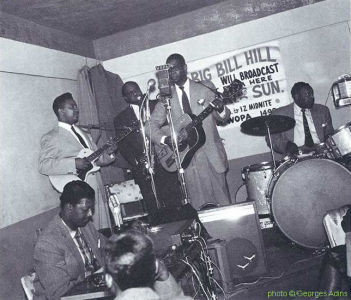 Big Bill Hill (disc jockey), Homesick James, g; J.T. Brown, ts; Elmore James, voc, g; Cassel Burraugh, dr at Thelma's Lounge, Chicago, 1959; diverse internet sources; photographer: Georges Adins; click to enlarge!