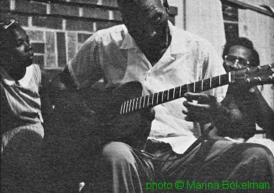 H E R B   Q U I N N   playing 'knife style' guitar; source: Back cover of Rounder LP 2009; photographer: Marina Bokelman