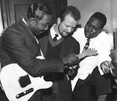 Muddy Waters, British skiffle bandleader Chas McDevitt, and Otis Spann; photo taken in England, 1958; photographer: ???