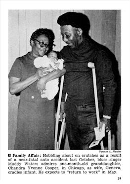 'Hobbing about on crutches as a result of a near-fatal auto accident last October [1969], blues singer Muddy Waters admires his one month old [b. March 5, 1970] great granddaughter, Chandra Yvonne Cooper, in Chicago as his wife Geneva, cradles infant. He expects to 'return to work' in May'; source: JET magazine Vol. XXXVIII, # 3 (April 16, 1970), p. 39; photographer: Norman L. Hunter