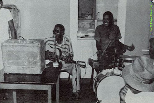 Lightnin' Hopkins & L.C.   'Lightnin' Jr.'   W I L L I A M S at the Sputnik Bar in Houston, TX, 1960; source: Back cover of Arhoolie LP F 1011 'Lightnin' Sam Hopkins'; photographer: Chris Strachwitz. The amp is a 1950s National Valco 1202 Sportsman Tweed, the guitar seems to be a Kay K-161 Thin Twin Jimmy Reed Model