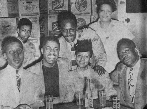 ; source: John Lee 'Sonny Boy' and Lacey Belle Williamson, with a young Muddy Waters (left) and Eddie Boyd (centre, standing), mid 1940s at the Club Georgia on Chicago's south side; other persons are Andrew 'Bo' Bolton (Muddy's long time chauffeur, sitting far right), the woman standing on the right is Mrs. White, wife of the club owner, the boy standing on the left is Mrs. White's son, who helped out at the club; source: Rowe 1975, p. 42 (credited to 'Chess Records'); a bit photoshopped by Stefan Wirz