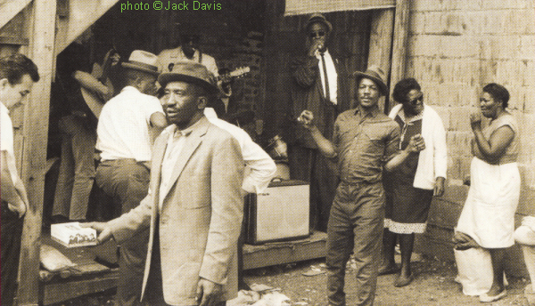 Collecting tips for Big John Wrencher at the corner of 14th and Newberry St. (Maxwell St. Market), Chicago, IL, 1965; The el. guitarist most likely is John Lee Granderson, but who might be the drummer (covert) and the acoustic guitarist (averted)? source: Booklet accompanying Shanachie DVD/CD 6801 (US 2008) 'And This Is Free - The Life and Times of Chicago's Legendary Maxwell Street', p. 21; photographer: Jack Davis
